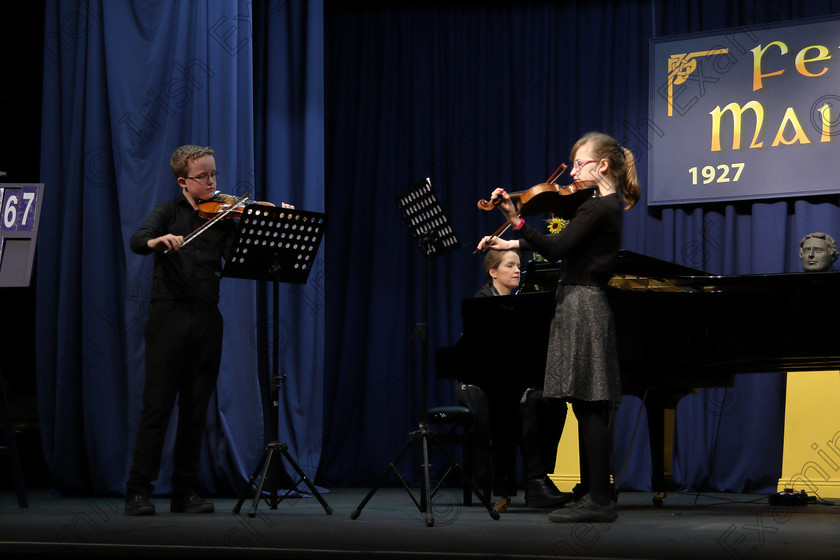 Feis01022018Thu01 
 1
Brother and Sister Duo Cillian Ó Cathasaigh and Niamh Ní Cathasaigh from Farran performing Accompanied by their mother Caroline Uí Cathasaigh.
 Instrumental Music Class: 267: Duo Classes and Chamber Music Junior Feis Maitiú 92nd Festival held in Fr. Matthew Hall. EEjob 01/02/2018 Picture: Gerard Bonus.