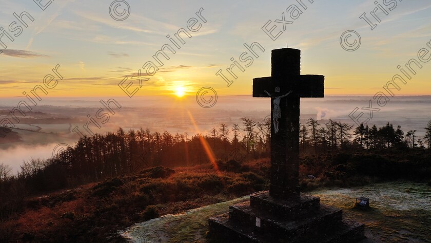 DJI 0664 
 An early-morning photograph that I captured on the summit of Corrin Hill near Fermoy, County Cork. Captured the landscape photo as sunrise had just presented over the West Waterford horizon in the distance. The low-lying valley was partially-shrouded in a mist and fog that drifted in an early-morning frosty breeze and as the sun began to rise-up over the countryside, the landscape took-on a golden perspective. In the foreground is a large stone cross with an image of the crucified Christ upon that was erected in 1932 to celebrate the Eucharistic Congress. I captured this photo on my morning trek.